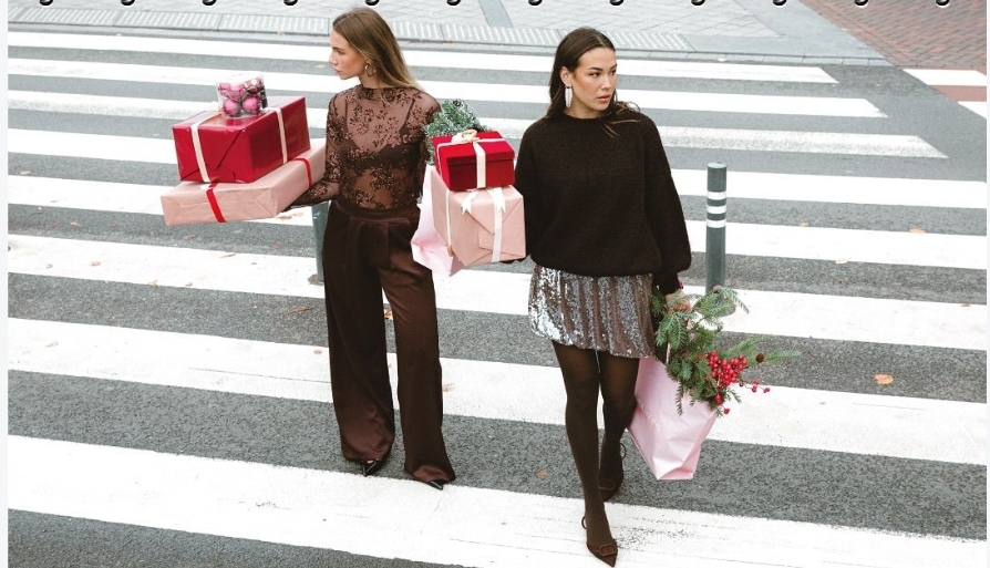 Holiday shoppers carrying gifts across a city crosswalk